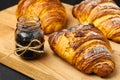 Freshly baked croissant with a berry jam in a jar on a wooden desk. French breakfast concept. Homemade pastry. Royalty Free Stock Photo