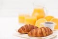 Freshly baked croissant, orange juice, fresh fruits, cup of coffee on white wooden background. French breakfast. Fresh Royalty Free Stock Photo