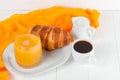 Freshly baked croissant orange juice, jam, cup of black coffee on white wooden background. French breakfast. Fresh pastries for mo Royalty Free Stock Photo