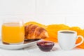 Freshly baked croissant orange juice, jam, cup of black coffee on white wooden background. French breakfast. Fresh pastries for mo Royalty Free Stock Photo