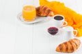 Freshly baked croissant orange juice, jam, cup of black coffee on white wooden background. French breakfast. Fresh pastries for mo Royalty Free Stock Photo