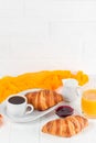 Freshly baked croissant orange juice, jam, cup of black coffee on white wooden background. French breakfast. Fresh pastries for mo Royalty Free Stock Photo