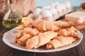 Freshly baked croissant on the plate with ingredients and kitchen utencil on the wooden table. Royalty Free Stock Photo