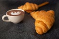 Freshly baked croissants on a black background with a white coffee cup,breakfast bread brown beverage morning,Concept: meal Royalty Free Stock Photo