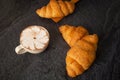 Freshly baked croissants on a black background with a white coffee cup,breakfast bread brown beverage morning,Concept: meal Royalty Free Stock Photo