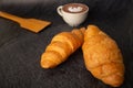 Freshly baked croissants on a black background with a white coffee cup,breakfast bread brown beverage morning,Concept: meal Royalty Free Stock Photo