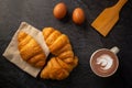 Freshly baked croissants on  black background with a white coffee cup,breakfast bread brown beverage morning,Concept: meal Royalty Free Stock Photo