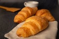 Freshly baked croissants on a black background with a white coffee cup,breakfast bread brown beverage morning,Concept: meal Royalty Free Stock Photo