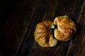 Freshly baked croissants in a black ceramic plate on the dark wooden background. Baking/pastry background. Concept for croissants Royalty Free Stock Photo