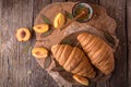 Freshly baked croissants with fruit jam, caramel and honey on wooden boards. Royalty Free Stock Photo