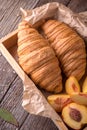 Freshly baked croissants with fruit jam, caramel and honey on wooden boards. Royalty Free Stock Photo