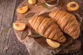 Freshly baked croissants with fruit jam, caramel and honey on wooden boards. Royalty Free Stock Photo