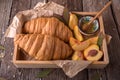 Freshly baked croissants with fruit jam, caramel and honey on wooden boards. Royalty Free Stock Photo