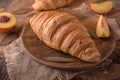 Freshly baked croissants with fruit jam, caramel and honey on wooden boards. Royalty Free Stock Photo