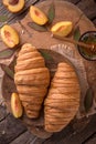 Freshly baked croissants with fruit jam, caramel and honey on wooden boards. Royalty Free Stock Photo