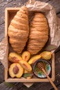 Freshly baked croissants with fruit jam, caramel and honey on wooden boards. Royalty Free Stock Photo