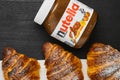 Freshly baked croissants with nutella on a black background. Traditional french or italian breakfast. Concept of