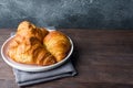 Freshly baked croissants on a plate, dark background, copy space Royalty Free Stock Photo