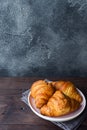 Freshly baked croissants on a plate, dark background, copy space Royalty Free Stock Photo