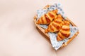 Freshly baked croissants in wicker basket on light background Royalty Free Stock Photo