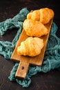 Freshly baked croissants on wooden cutting board, top view Royalty Free Stock Photo