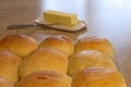 Freshly baked dinner rolls on cooling rack with knife and butter Royalty Free Stock Photo