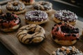 Freshly baked donuts, with chocolate and vanilla, differently decorated, served on a cutting board