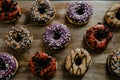 Freshly baked donuts, with chocolate and vanilla, differently decorated, served on a cutting board