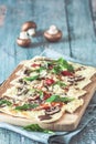 Freshly baked flammkuchen, traditional french tarte flambee or german pizza in a vegetarian recipe with mushrooms, cream cheese, Royalty Free Stock Photo