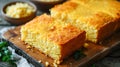 Freshly baked fluffy buttery cornbread with golden crust on a wooden cutting board. Traditional Southern states cuisine