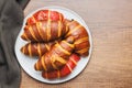 Freshly Baked fruity and Chocolate Croissants on plate on kitchen table. Top view