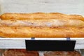 Freshly baked gluten free baguette breads on white wooden shelves. Royalty Free Stock Photo
