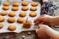 Freshly baked heart-shaped cookies on parchment paper, lavender flower