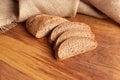 Freshly baked homemade bread with bran on a wooden background and burlap cut into slices. Foodphoto. Royalty Free Stock Photo