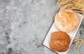 Freshly baked homemade bread, french sourdough baguette with crispy crust and ears of rye and wheat on concrete background with Royalty Free Stock Photo