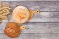 Freshly baked homemade bread, french sourdough baguette with crispy crust and ears of rye and wheat on wooden background with Royalty Free Stock Photo