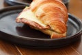 Freshly baked homemade delicious croissant sandwich ham cheese in black plate on wooden breakfast table Royalty Free Stock Photo