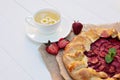 Freshly baked homemade galette or open strawberry pie and fresh mint leaves with a cup of chamomile herbal tea, summer food. Soft Royalty Free Stock Photo