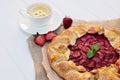 Freshly baked homemade galette or open strawberry pie and fresh mint leaves with a cup of chamomile herbal tea, summer food. Soft Royalty Free Stock Photo