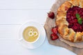 Freshly baked homemade galette or open strawberry pie and fresh mint leaves with a cup of chamomile herbal tea, summer food. Soft Royalty Free Stock Photo