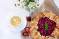 Freshly baked homemade galette or open strawberry pie and fresh mint leaves with a cup of chamomile herbal tea, summer food. Soft Royalty Free Stock Photo