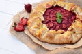 Freshly baked homemade galette or open strawberry pie and fresh mint leaves, summer food. Soft selective focus Royalty Free Stock Photo