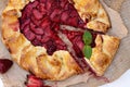 Freshly baked homemade galette or open strawberry pie and fresh mint leaves, summer food. Soft selective focus Royalty Free Stock Photo