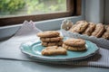 Homemade ginger biscuits on a plate at a window