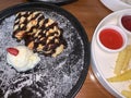 freshly baked homemade heart shaped Belgian waffles, covered with chocolate syrup and vanilla ice cream with sliced of straw berry Royalty Free Stock Photo