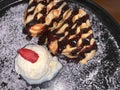 freshly baked homemade heart shaped Belgian waffles, covered with chocolate syrup and vanilla ice cream with sliced of straw berry Royalty Free Stock Photo