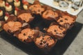 Freshly baked honey raisin muffins in rustic setting. Vintage pewter dishes with ingredients in background. Low key still life di