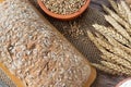 Freshly baked loaf of whole wheat bread with sunflower seeds and flour on wooden cutting board with rustic background Royalty Free Stock Photo