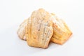 Freshly baked Madeleine cookies sprinkled with sugar powder close-up on the table, petite madeleine isolated on white backgrou