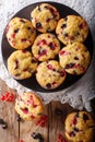 Freshly baked muffins with black and red currant berries close-up. Vertical top view from above Royalty Free Stock Photo